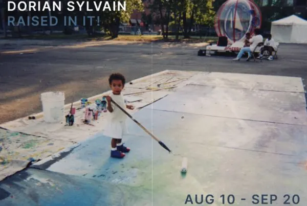 Archival photo of a child painting a large mural on the ground.